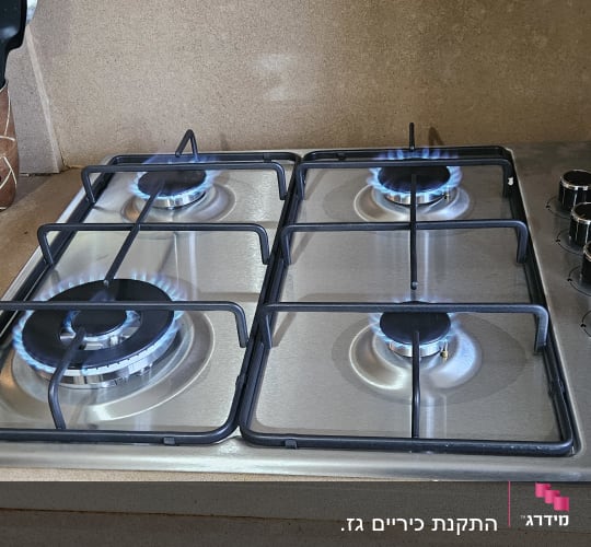 כיריים גז עם ארבעה מבערים דולקים